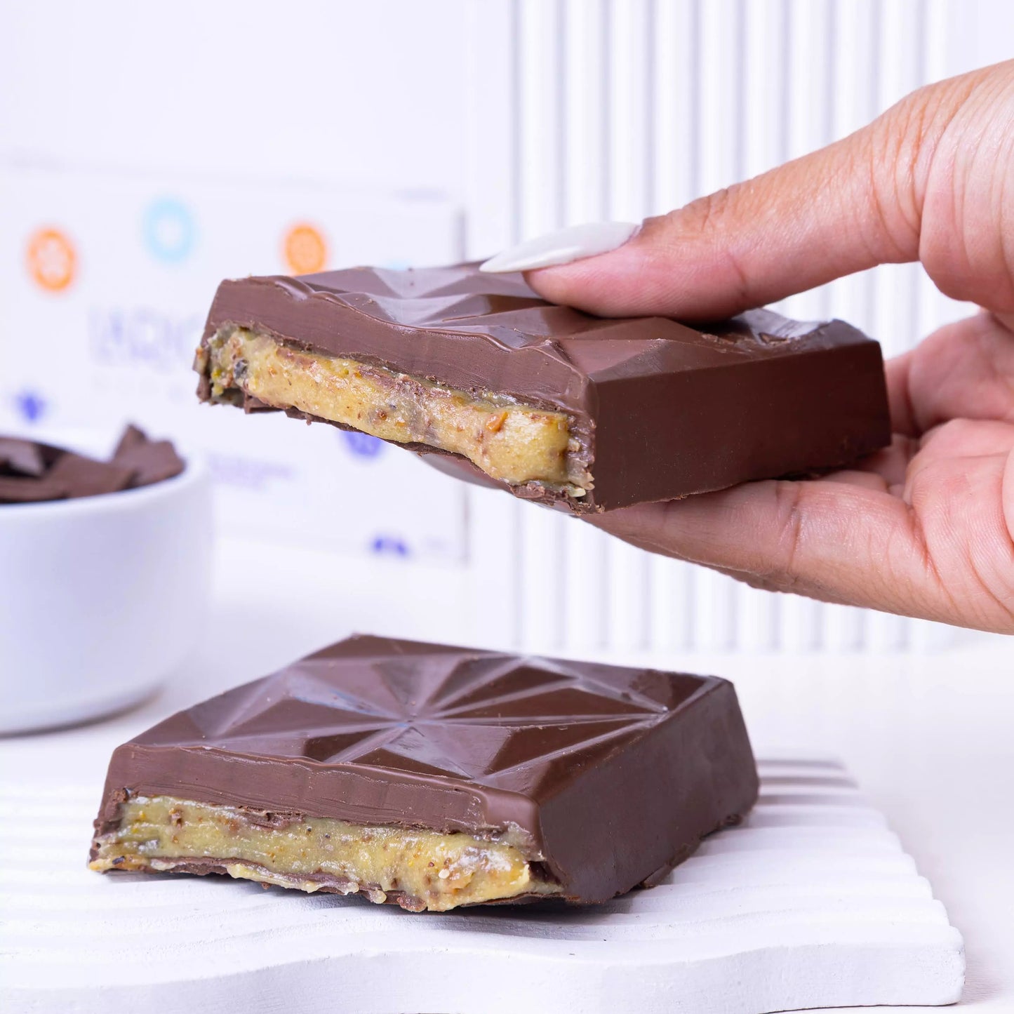 Barra proteica de chocolate meio amargo com recheio de pistache, sem açúcar, low carb e perfeita para quem ama um doce saudável e intenso.