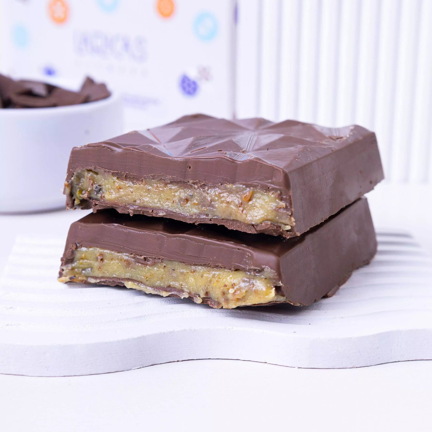 Barra proteica de chocolate ao leite com recheio de pistache, sem açúcar, cremosa e ideal para quem busca um doce saudável e nutritivo.