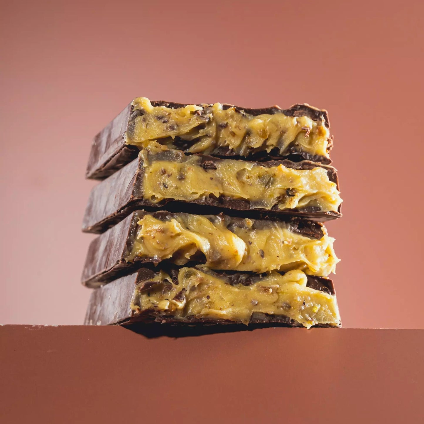 Barra preta recheada de Pistache Premium sem açúcar e proteica, com chocolate intenso e recheio cremoso para quem busca uma opção mais sofisticada.